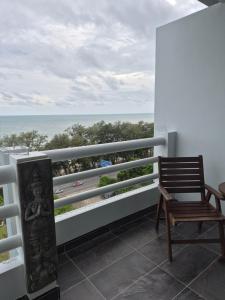 a balcony with a chair and a view of the ocean at New world condo1104 in Ban Chak Phai