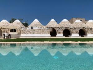 a building with a pool of water in front of it at Masseria Castelluzzo in Ceglie Messapica