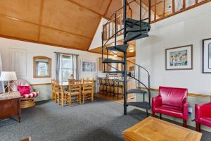 a living room with a spiral staircase and a dining room at 4060 - Foxhole in Kitty Hawk Beach +22 photos
