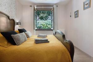 a bedroom with a yellow bed with a window at Gite Chante' Alouette – Le Bugue in Le Bugue