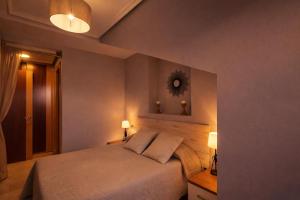 a bedroom with a bed with two lamps and a mirror at Apartamento turístico Aldamar in Llanes +25 photos