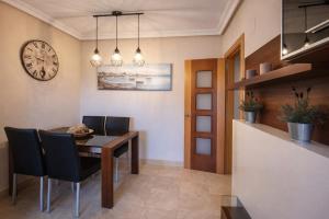 a dining room with a table and chairs and a clock at Apartamento turístico Aldamar in Llanes
