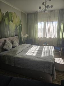 a bedroom with a large bed with flowers on the wall at Kate Sea Apartment in Pärnu