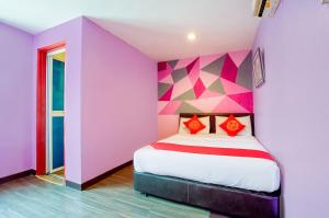a room with a bed with a colorful wall at 1st Inn Hotel Klang Sentral Meru in Klang