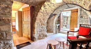a room with a stone wall with a chair and a window at Chambre d'hôtes L'Adrienne in Chazeaux