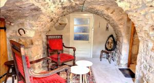 a room with two chairs and a table in a stone wall at Chambre d'hôtes L'Adrienne in Chazeaux +12 photos