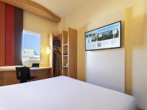 a room with a bed and a tv on a wall at Ibis Madrid Calle Alcalá in Madrid +82 photos