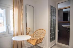 a room with two chairs and a table and a mirror at Flora in Tinos