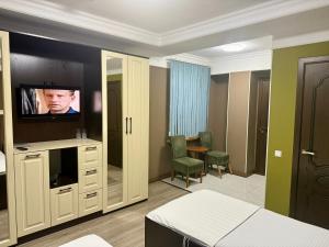 a hotel room with a bed and a flat screen tv at Monroe Hotel in Almaty