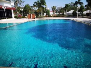 a large pool of blue water in front of a building at New world condo1104 in Ban Chak Phai