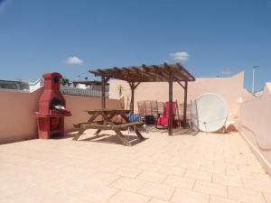 a patio with a picnic table and a wooden bench at Camposol House in Mazarrón