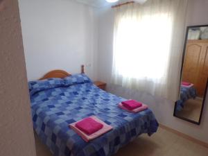 a bedroom with a bed with pink towels on it at Camposol House in Mazarrón