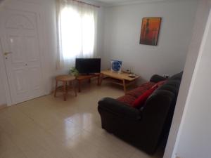 a living room with a black couch and a table at Camposol House in Mazarrón