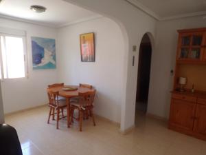 a dining room with a wooden table and chairs at Camposol House in Mazarrón