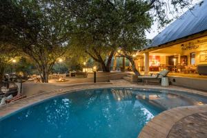 a swimming pool in the backyard of a house at Shimungwe Lodge, Thornybush Game Reserve in Hoedspruit