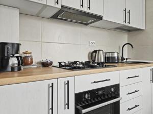 a kitchen with white cabinets and a stove top oven at Konstanzer12 - Free Parking Apt - AC in Iaşi +6 photos