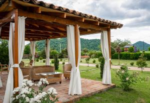 a wooden gazebo with chairs and a table at In Gremi Hotel in Gremi