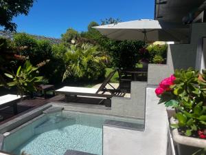 a swimming pool with a table and an umbrella at Studio Natalie in Marina di Massa