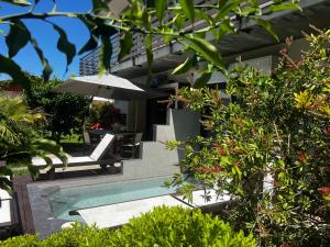 a house with a swimming pool and an umbrella at Studio Natalie in Marina di Massa