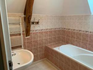a bathroom with a tub and a sink at Gite de Foulleray n 14 in Rouez +10 photos