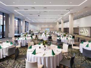a banquet hall with white tables and chairs at Novotel Poznan Centrum in Poznań