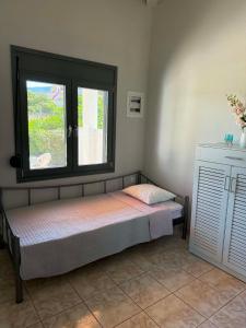 a bed in a room with a window at George's place in Plytra