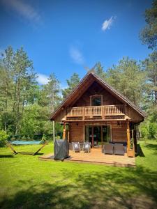 a log cabin with a deck and two chairs at Hankówka Mazury in Jerutki