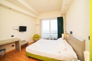 a bedroom with a bed and a desk and a window at Hotel Madison - Cattolica in Cattolica +26 photos