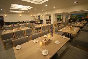 a restaurant with tables and chairs in a room at Hotel Sujata in Bodh Gaya