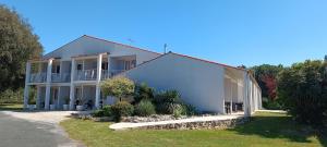 a white house with a balcony on the side of it at Les Chênes Verts in Saint-Savinien