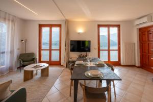 a living room with a table and chairs and a television at Lake Iseo Panorama Suite in Tavernola Bergamasca