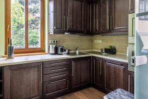 a kitchen with wooden cabinets and a window at Szent Margit Apartman in Veszprém