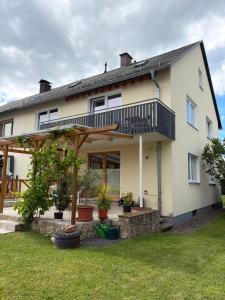 a large white house with a balcony and potted plants at Ruhiges City-Apartment mit Balkon in Selb