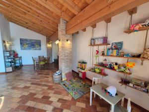 a living room with wooden ceilings and a brick pillar at Agriturismo Le Cipressine in Meolo +47 photos