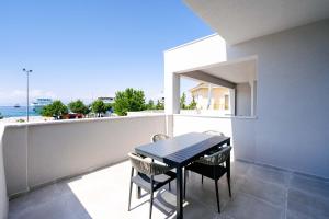 a table and chairs on a balcony with a view of the ocean at Orizon Apartments in Limenas