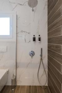 a shower in a bathroom with white marble at Orizon Apartments in Limenas +27 photos