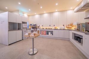 a large kitchen with white cabinets and a table in it at Giverny Hotel in Gyeongju