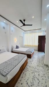 a bedroom with two beds and a ceiling fan at Real Casa in Anachal