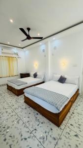 a bedroom with two beds and a ceiling fan at Real Casa in Anachal