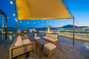 a rooftop patio with couches and chairs on a building at Giverny Hotel in Gyeongju