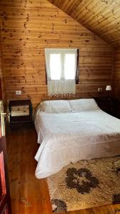 a bed in a wooden room with a window at Farma Sotira Agroturizem in Leskovik