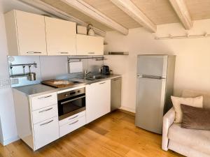 a kitchen with white cabinets and a stainless steel refrigerator at Le Sirene in Parzanica