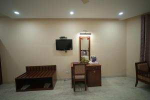 a room with a mirror and a tv on a wall at Hotel Sujata in Bodh Gaya