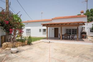 a small white house with a patio and a table at La Huertina C2 in Zahora