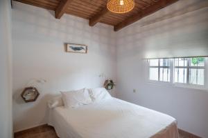 a bedroom with a white bed and a window at La Huertina C2 in Zahora