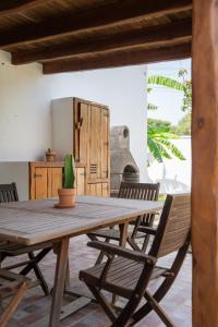 a wooden table with chairs and a potted plant at La Huertina C1 in Zahora