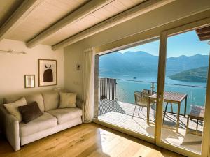 a living room with a couch and a large window at Le Sirene in Parzanica