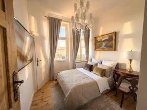 a bedroom with a bed and a desk and a chandelier at Belle Époque Sopot in Sopot