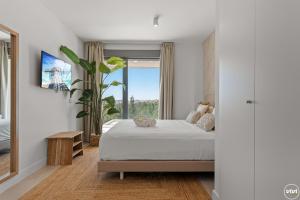 a bedroom with a bed and a large window at ViVi Homes - Marisol Pool, Sauna, Gym, Spa & Beach in Mijas Costa