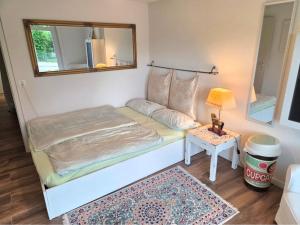 a bedroom with a bed with a mirror and a table at Charmante Waldrandidylle in Kreuzlingen